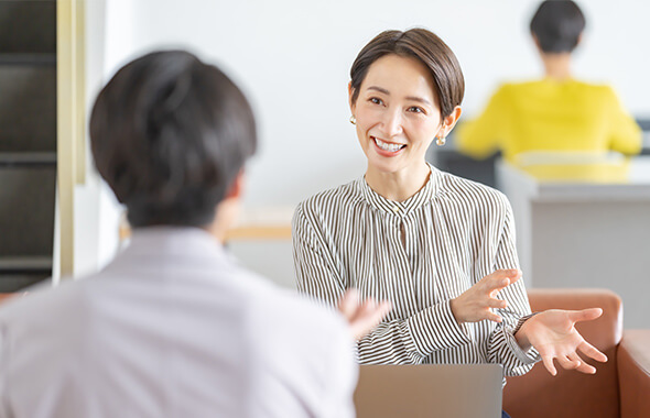相談員と相談者がにこやかに話し合いをしている様子